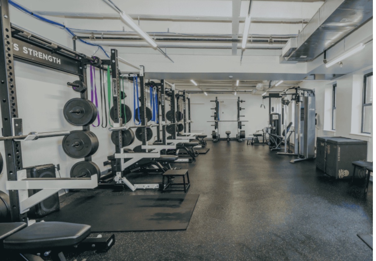 CATS Academy strength and conditioning weight room with squat racks and turf