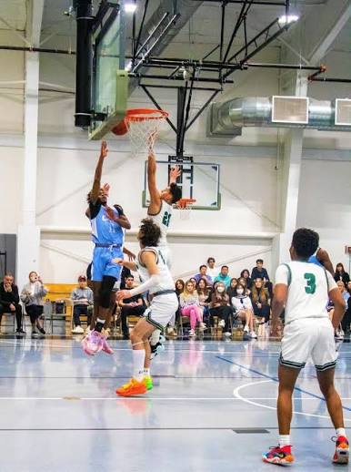 CATS Academy boys basketball player finishing at the rim during a prep school game
