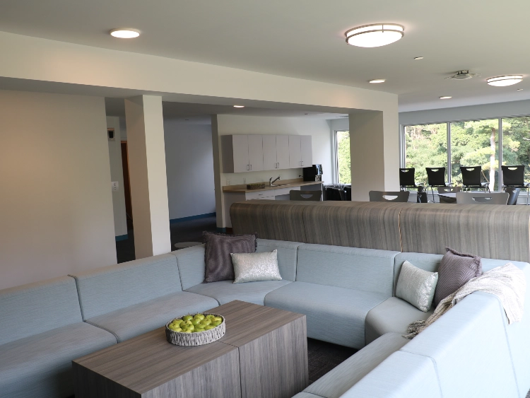 Student common room with sectional seating and large windows